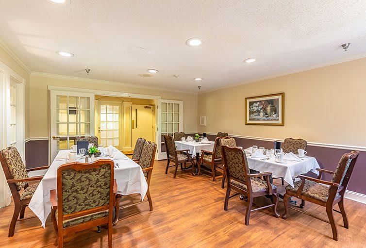 A cozy dining room setup with elegant tables and chairs, ambient lighting, and tasteful decor.