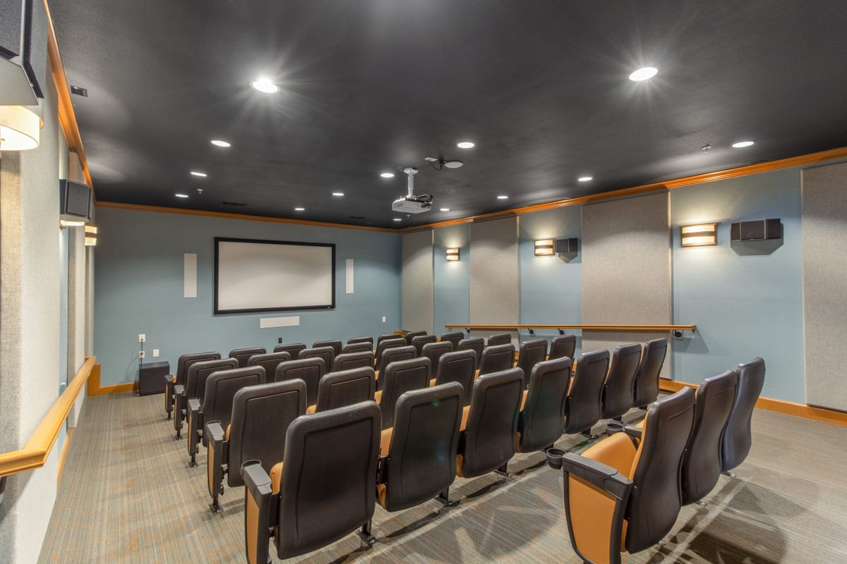 A small home theater with rows of comfortable seating and a large screen.