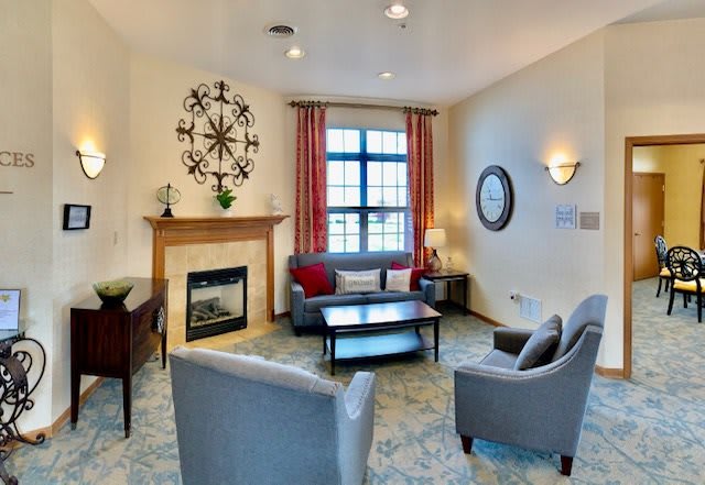A modern living room featuring a cozy fireplace, stylish furniture, and bright natural lighting.