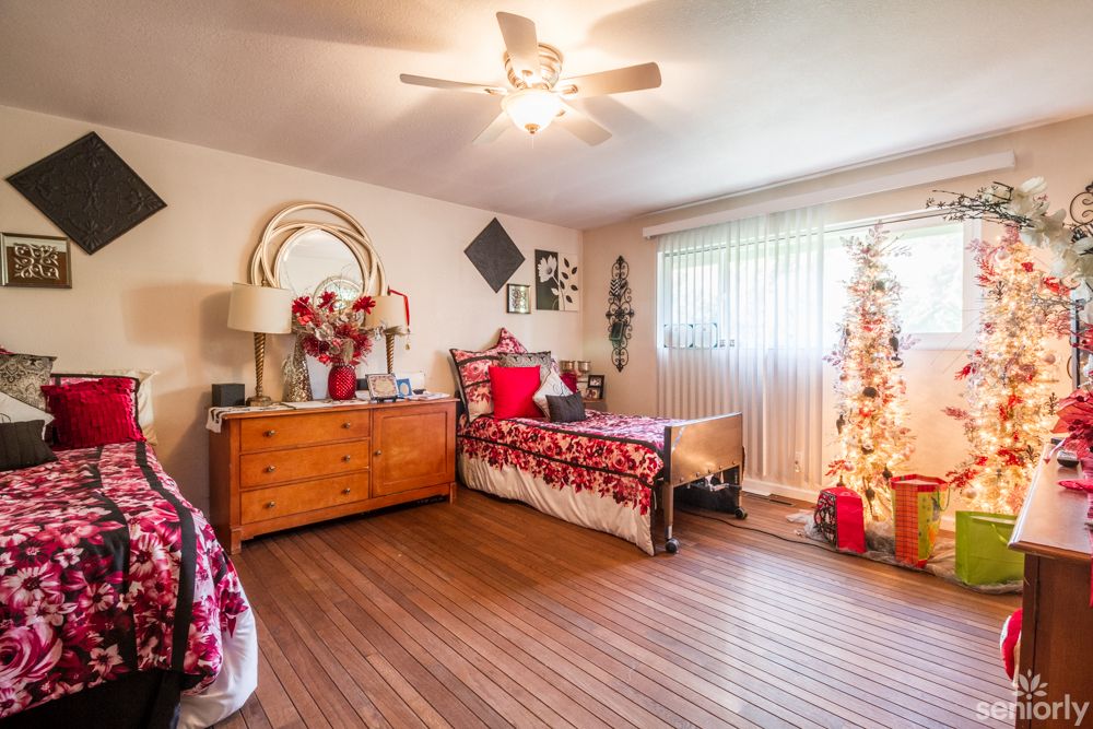 A cozy bedroom decorated with festive Christmas ornaments and a beautifully adorned tree.