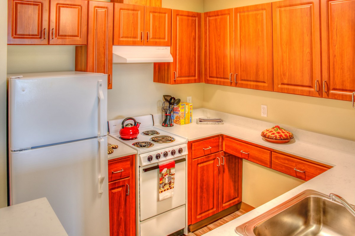 A cozy kitchen with wooden cabinets and modern appliances.