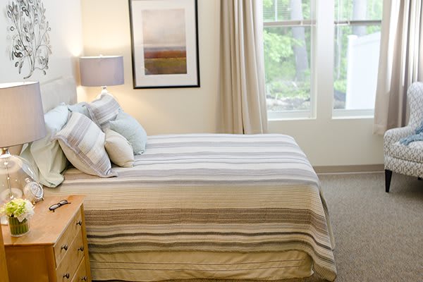 A bright and cozy bedroom with striped bedding and soft lighting.