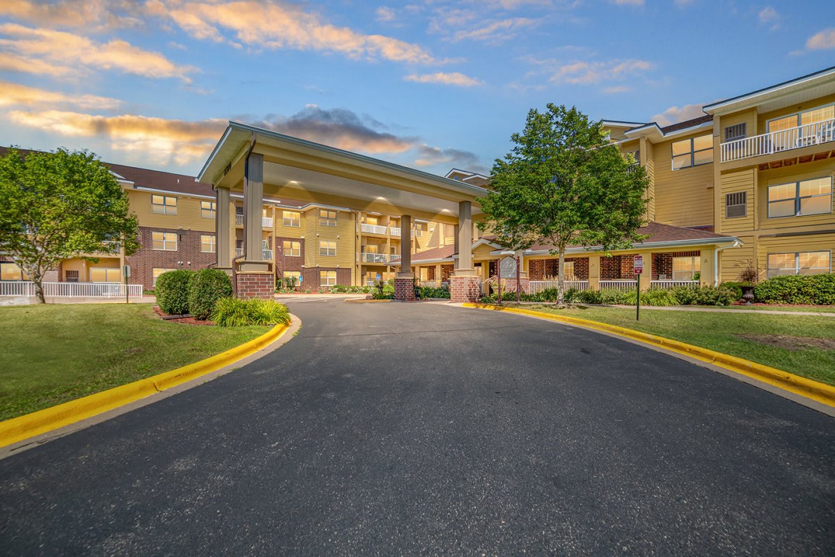 A welcoming entrance of a modern building with a landscaped driveway.