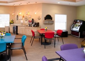A cozy cafe with colorful chairs and a coffee station.