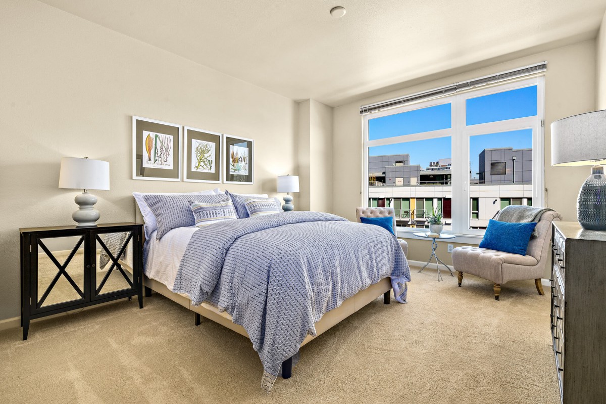 A modern bedroom with a large window offering a bright, comforting atmosphere.
