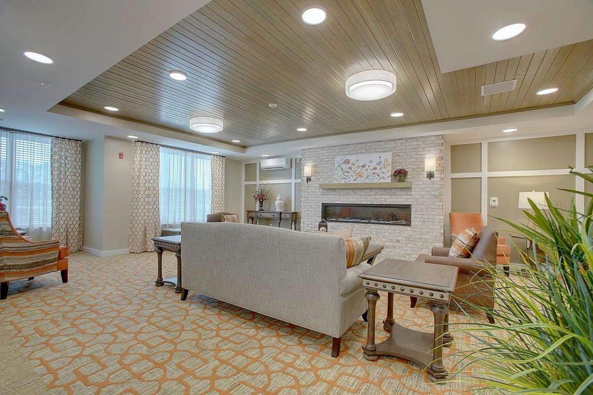 A cozy living room with a sofa, tables, and a fireplace.