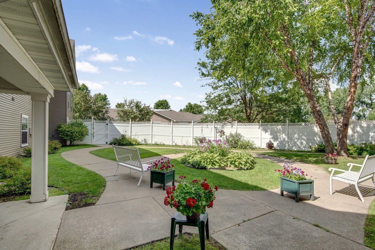 A tranquil backyard garden with a pathway and blooming flowers.