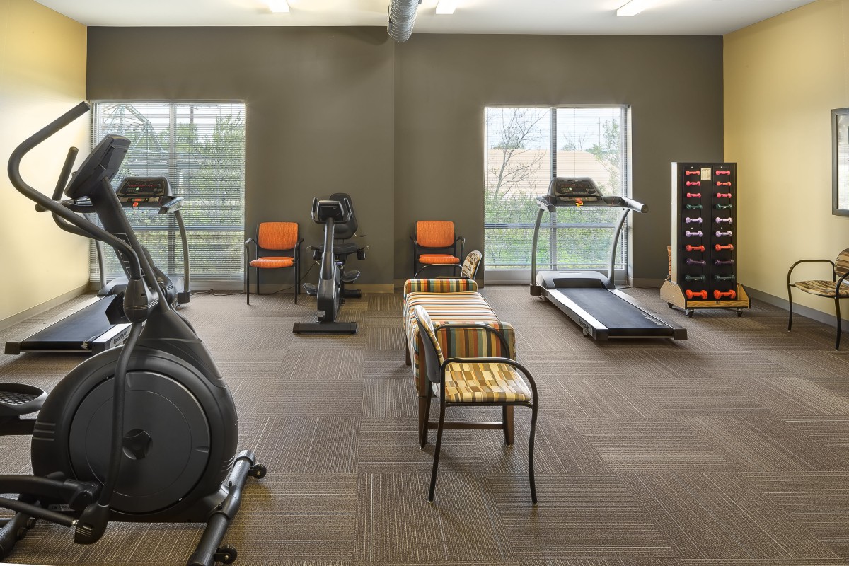A well-equipped gym with exercise machines and free weights.