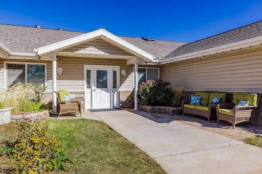 A welcoming entrance to a residential home, featuring a well-maintained pathway and seating area.