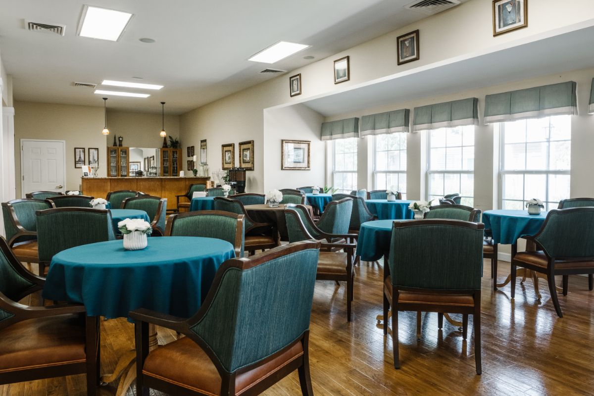 A spacious and well-lit dining area with multiple tables and chairs arranged neatly.
