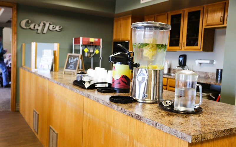 A beverage station featuring infused water, coffee, and tea in an office setting.