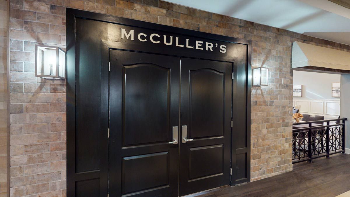 Entrance to McCULLER'S restaurant with double doors against a brick wall.