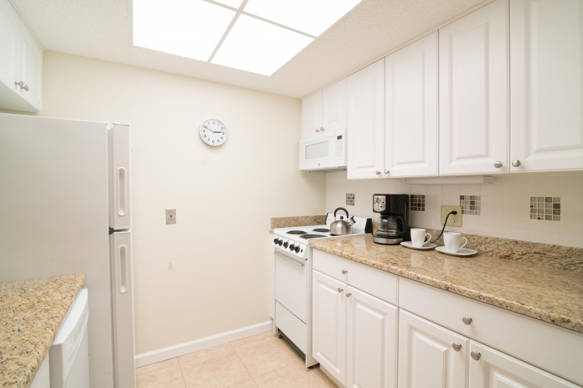 A bright kitchen with white cabinets and modern appliances.