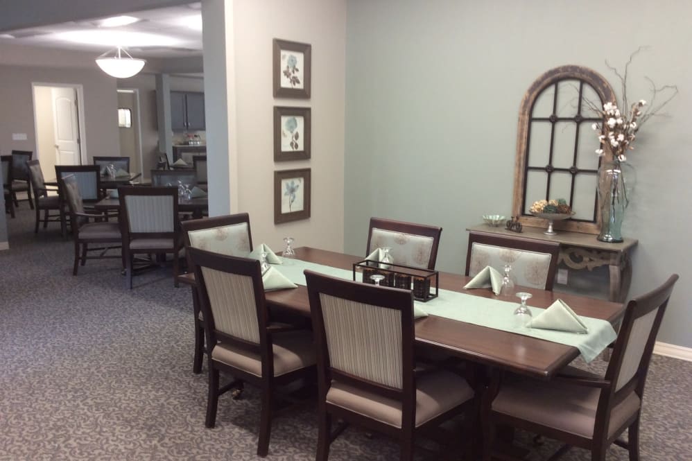 A well-decorated dining room with a large table and chairs, featuring tasteful decor.