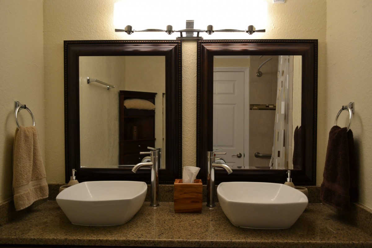 A modern bathroom with double sinks and large framed mirrors.