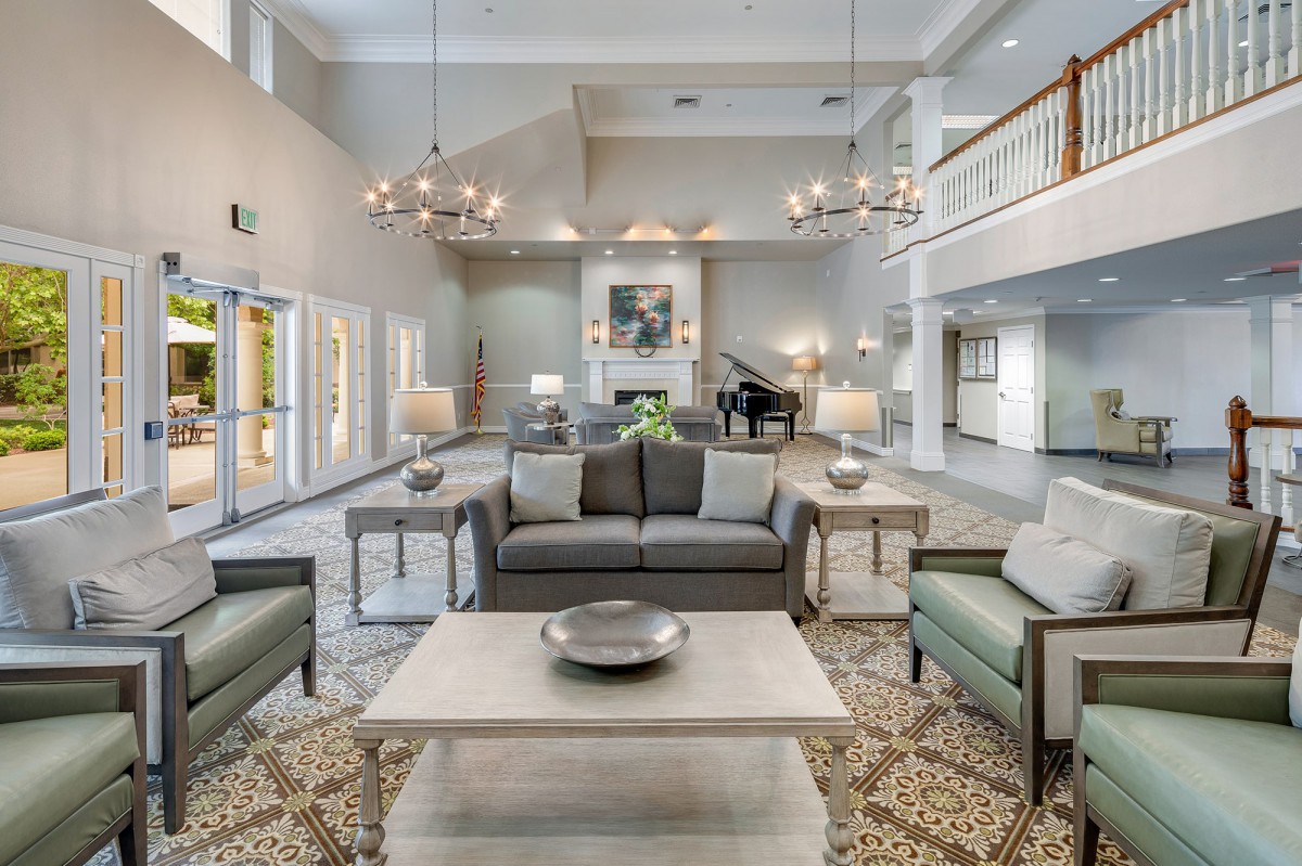 A spacious and elegantly decorated lobby featuring comfortable seating and modern chandeliers.