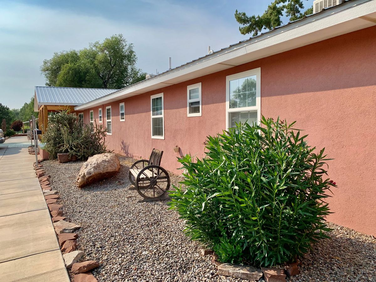 A house with a xeriscaped front yard featuring succulents, rocks, and a wooden chair.