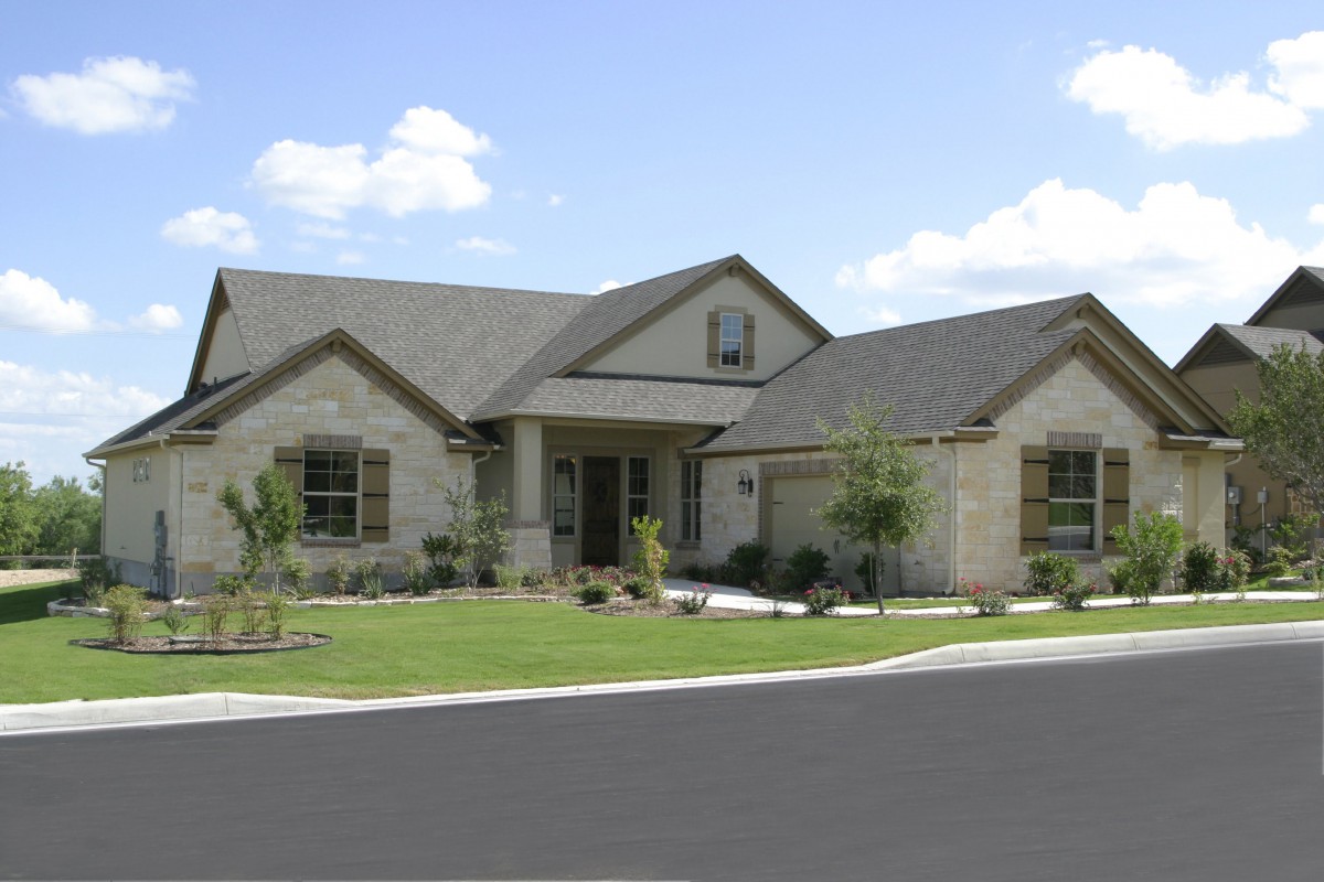 A suburban house with a well-maintained yard and clear sky.
