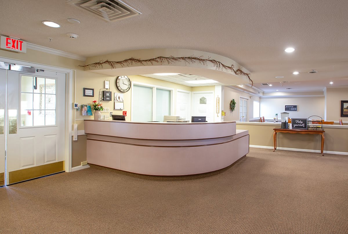 A clean and modern reception area with a curved desk and office furnishings.