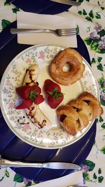 A plate with assorted pastries, strawberries, and a donut.