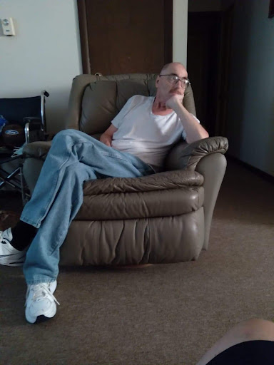 A person sitting in a chair, lost in thought.
