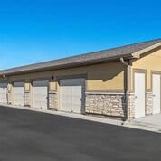 A row of garage units under a clear blue sky.