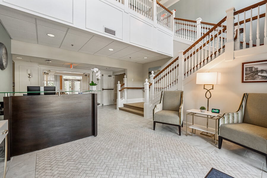A welcoming lobby featuring a reception desk, seating area, and staircase.