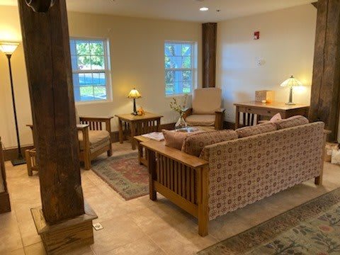 A cozy living room with wooden furniture and warm lighting.