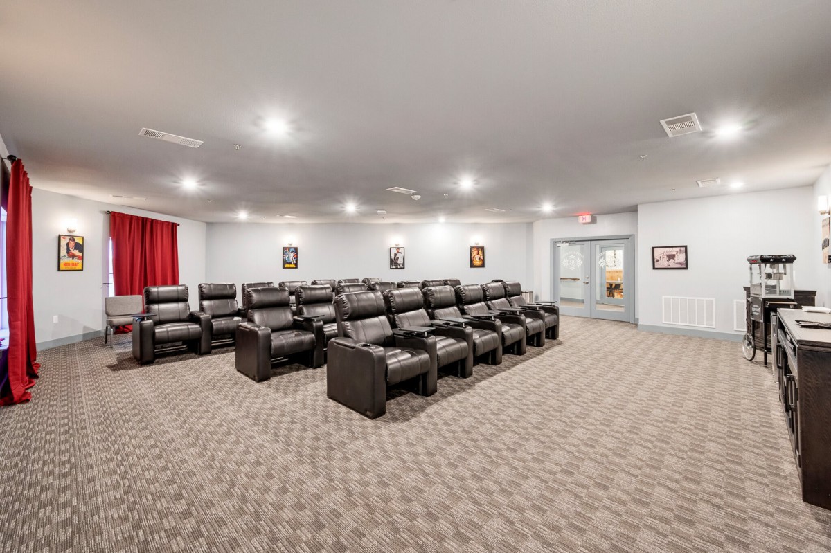 A cozy home theater room featuring multiple recliner seats and soft lighting.