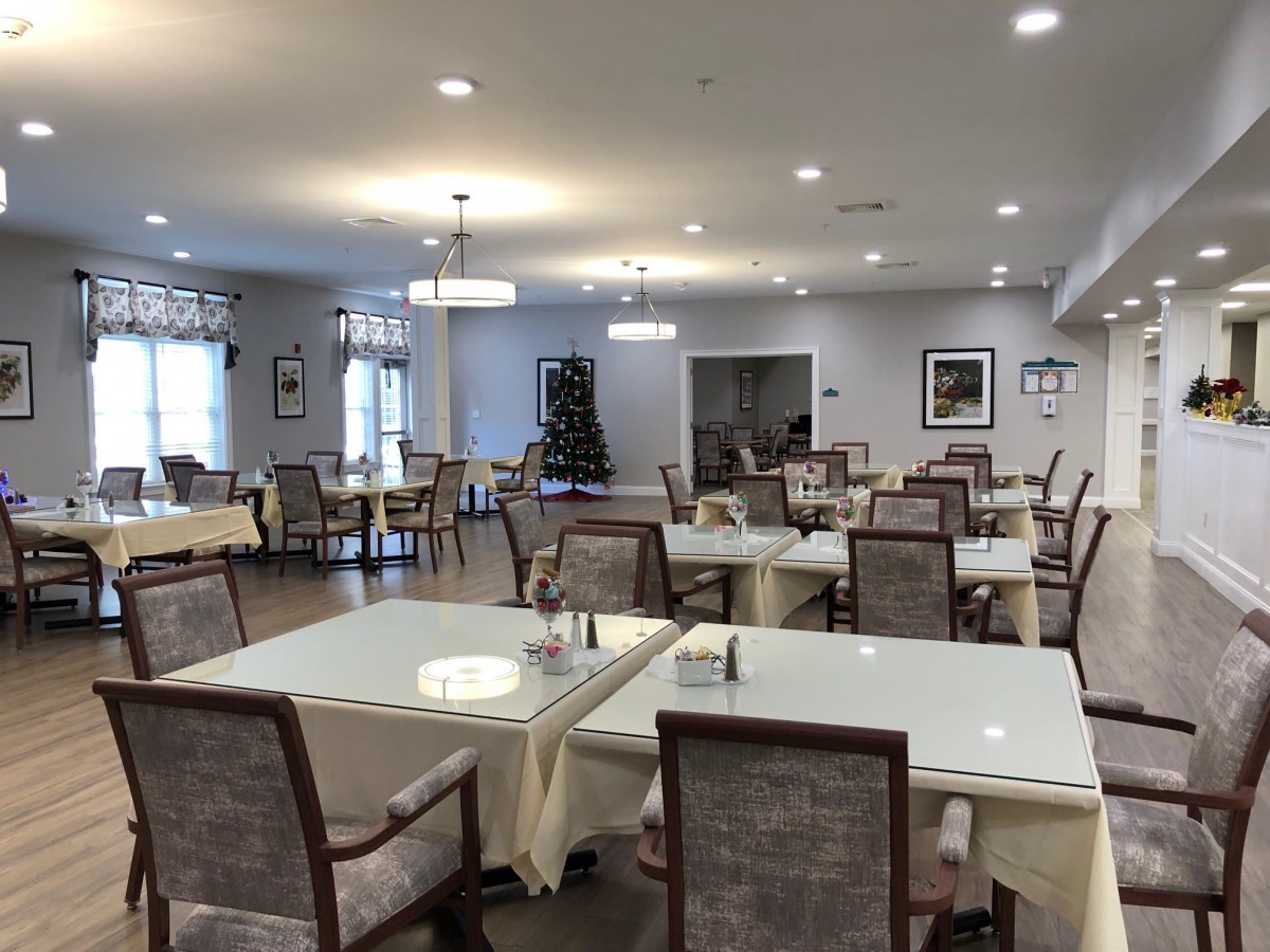 A well-lit dining area with neatly arranged tables and chairs.