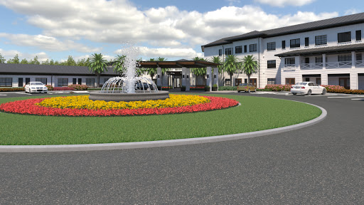A beautifully landscaped area featuring a fountain and vibrant flower beds in front of a modern building.
