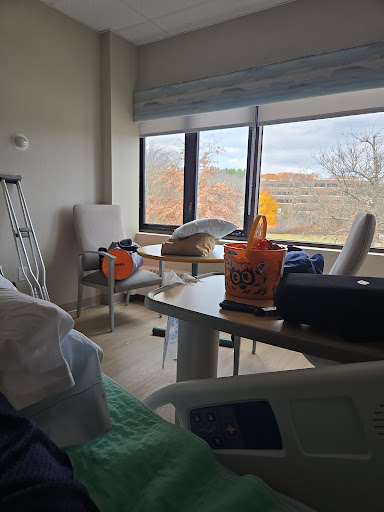 A view of a hospital patient room with natural light streaming through the window, featuring minimal furnishings.