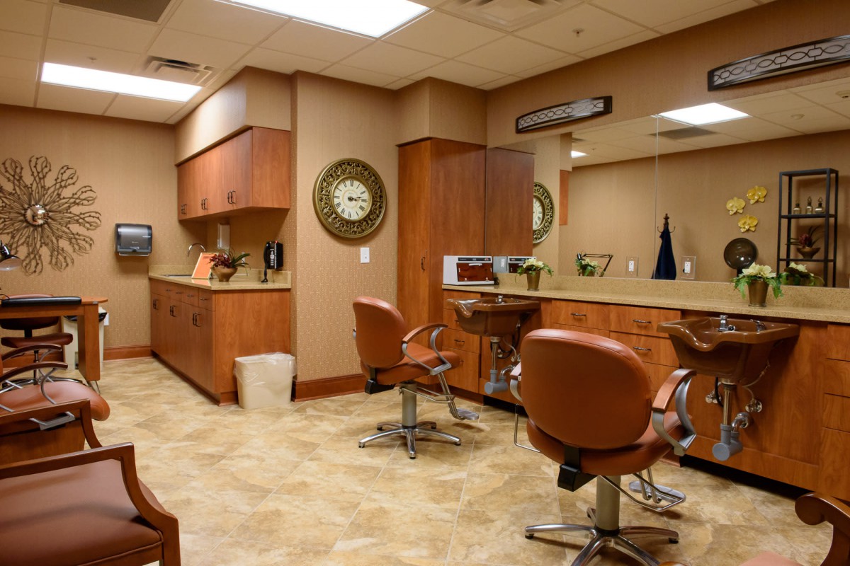 An interior view of a hair salon with chairs and mirrors.