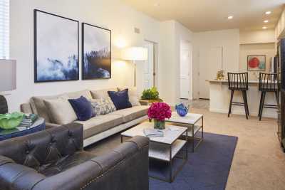 A modern living room with a comfortable sofa, coffee tables, stylish decor, and framed artwork on the wall.
