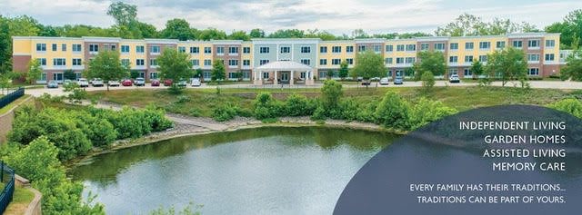 A modern building located near a tranquil pond surrounded by greenery.