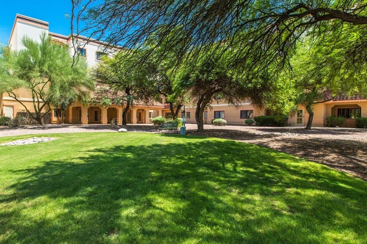 A sunny day on a peaceful campus with trees and well-maintained lawns.