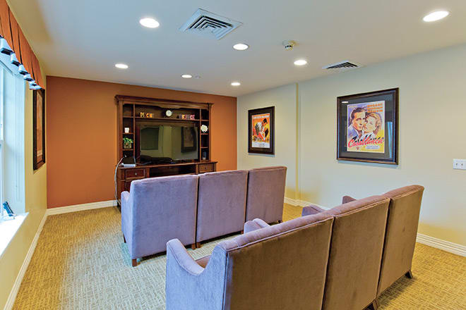 Cozy home theater room with comfortable seating and wall-mounted artwork.