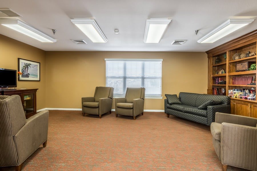 A calm and comfortable waiting room with chairs, a sofa, and a window.