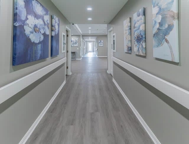 A modern hallway featuring artwork on the walls and sleek flooring.