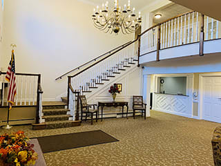 A spacious lobby with a grand staircase and chandelier.