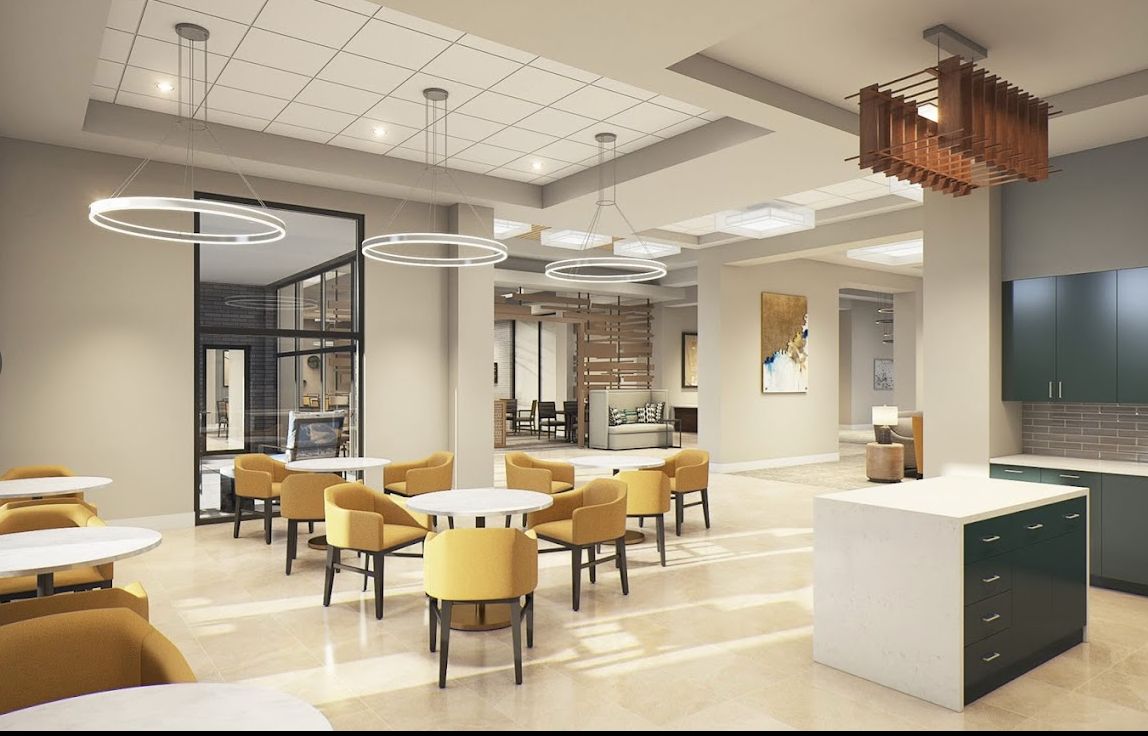 A modern office lobby with yellow chairs and contemporary lighting.
