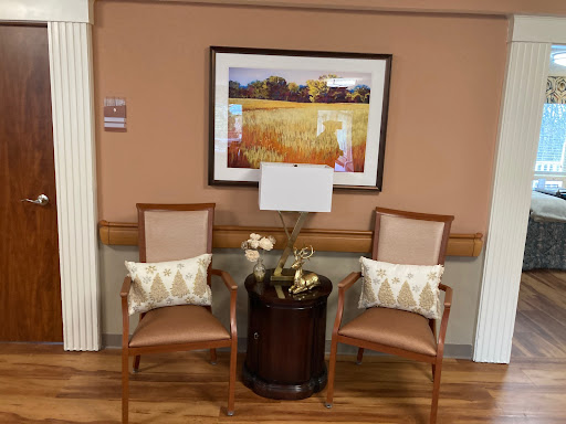 A cozy seating arrangement featuring two chairs, a lamp, and decorative artwork on the wall.
