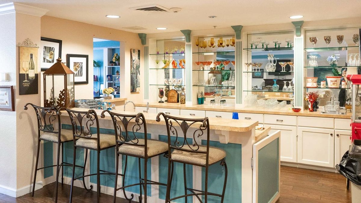 A stylish home bar with elegant bar stools and glass shelving.