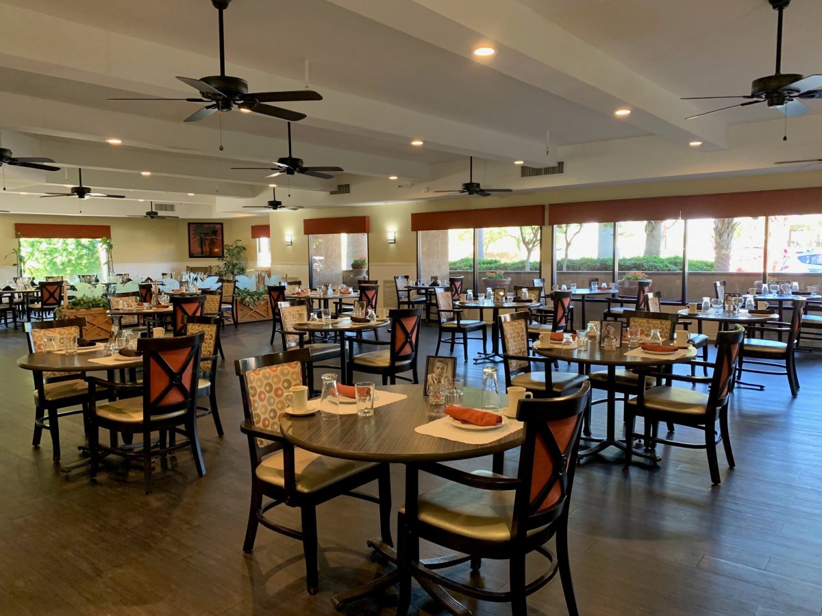An empty restaurant dining area with neatly arranged tables and chairs.