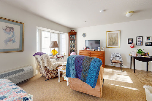 A cozy living room filled with natural light, featuring comfortable seating and homey decor.