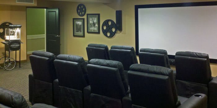 A cozy home theater setup with comfortable seating and a large projector screen.