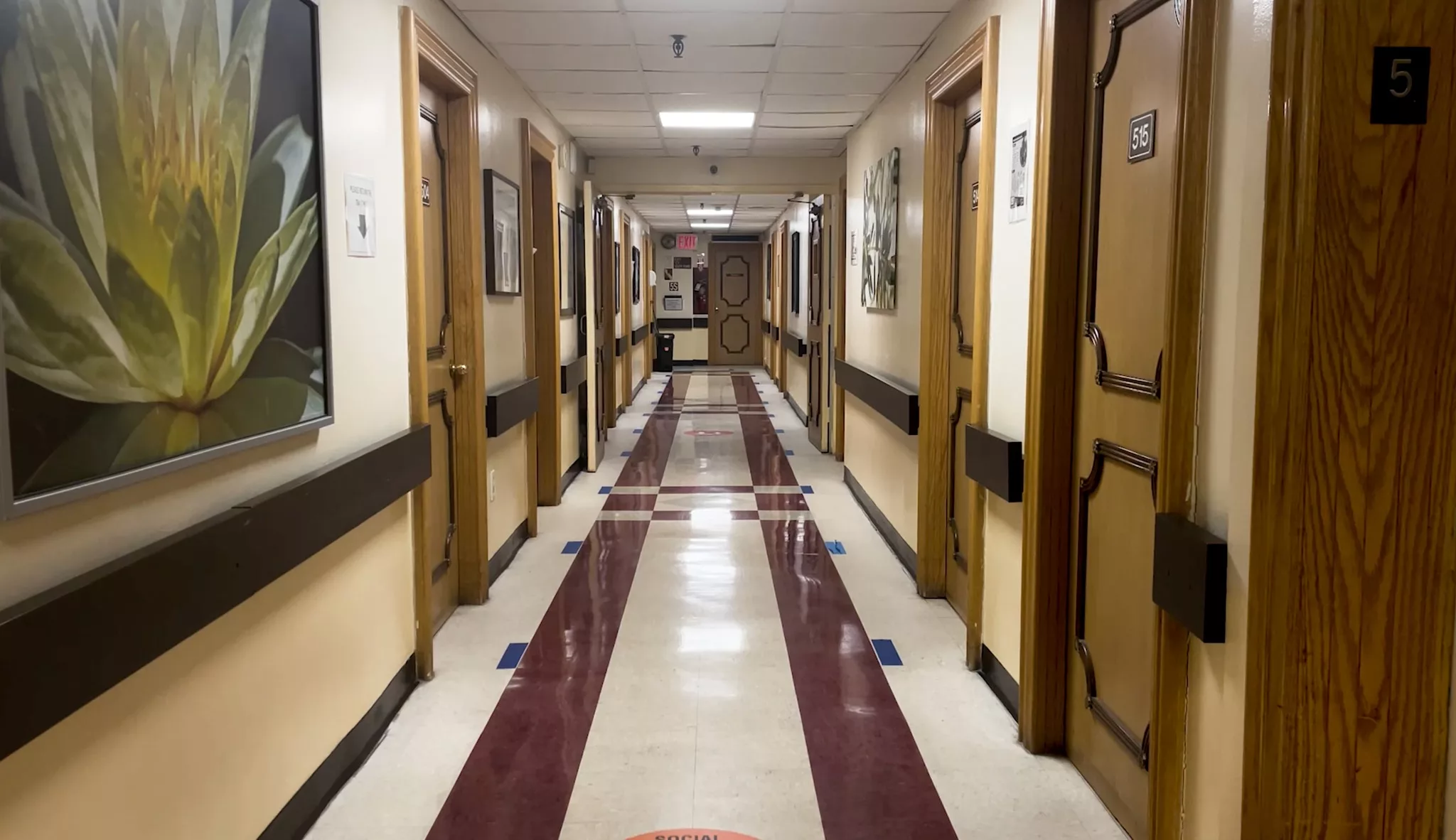 A well-lit corridor with multiple doors on either side.