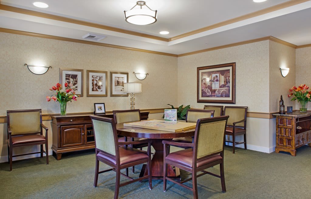 A cozy dining area with a wooden table and chairs, surrounded by warm decor and lighting.