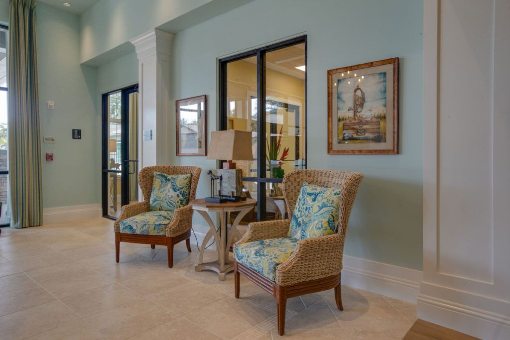 A cozy lobby area with patterned chairs, artwork on the walls, and soft lighting.