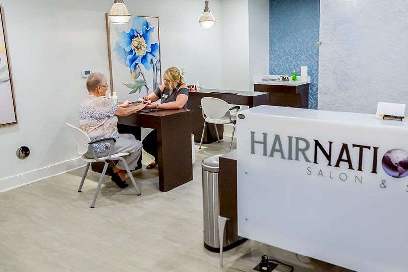 A stylish salon interior where a customer receives a manicure treatment.